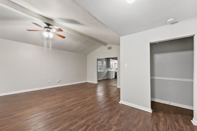 unfurnished living room with ceiling fan, dark hardwood / wood-style flooring, lofted ceiling with beams, and a textured ceiling