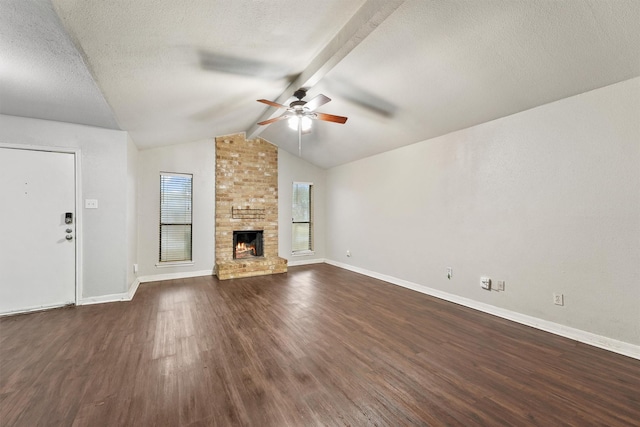 unfurnished living room with dark hardwood / wood-style flooring, a brick fireplace, a textured ceiling, and vaulted ceiling with beams