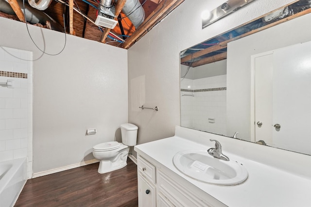 full bathroom featuring vanity, tiled shower / bath, hardwood / wood-style floors, and toilet