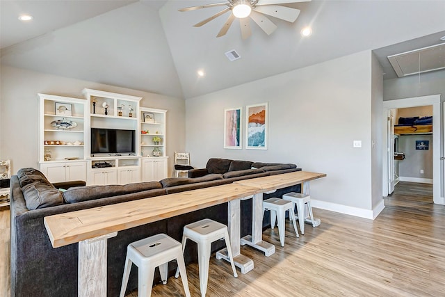 living room featuring ceiling fan, high vaulted ceiling, and light hardwood / wood-style floors