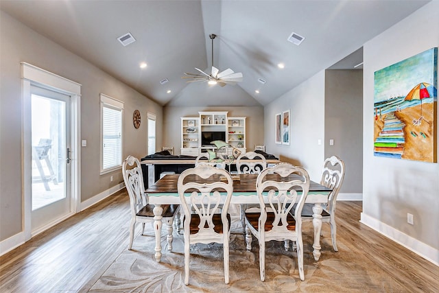 dining space featuring ceiling fan, lofted ceiling, and light wood-type flooring