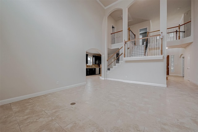 unfurnished living room featuring a towering ceiling