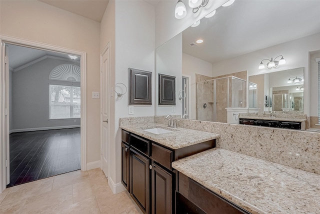 bathroom featuring walk in shower, lofted ceiling, vanity, and tile patterned flooring