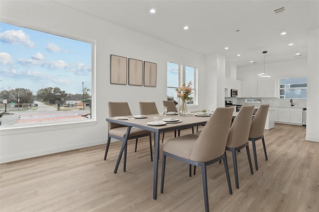 dining space with sink and light wood-type flooring