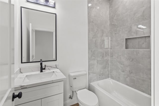 full bathroom featuring tiled shower / bath combo, vanity, and toilet