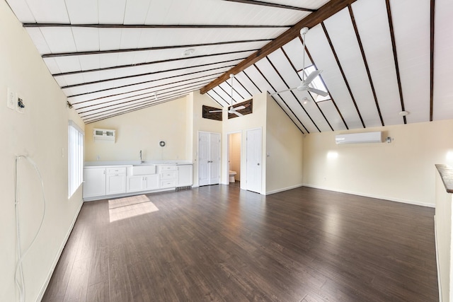 unfurnished living room featuring sink, high vaulted ceiling, an AC wall unit, dark hardwood / wood-style floors, and beam ceiling