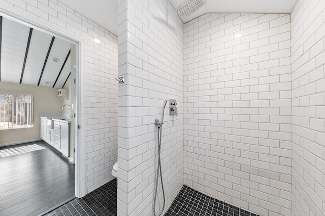 bathroom featuring vaulted ceiling, toilet, and tiled shower