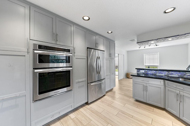 kitchen featuring stainless steel appliances, light hardwood / wood-style floors, sink, and gray cabinetry