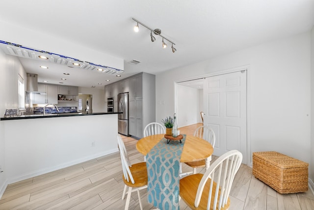 dining area featuring sink and light hardwood / wood-style floors