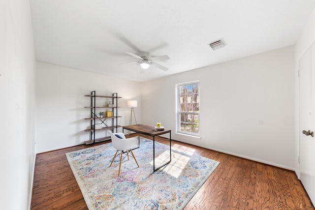 home office with dark wood-type flooring and ceiling fan