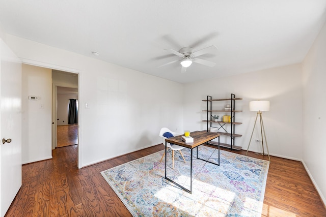 home office with dark wood-type flooring and ceiling fan