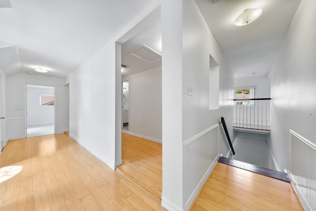 corridor with vaulted ceiling and light hardwood / wood-style floors