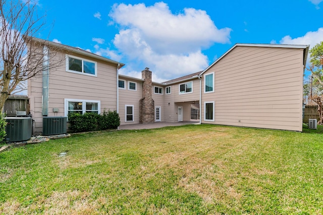 rear view of property featuring central AC, a patio area, and a lawn