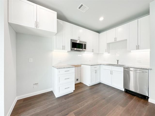 kitchen with white cabinetry, stainless steel appliances, dark hardwood / wood-style floors, and sink