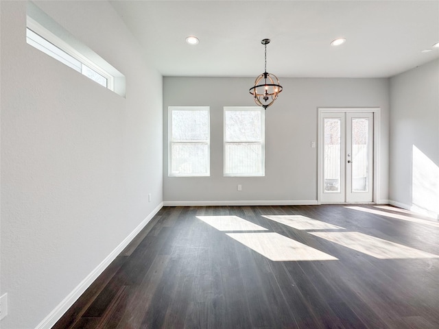 interior space with a notable chandelier, dark hardwood / wood-style floors, and french doors