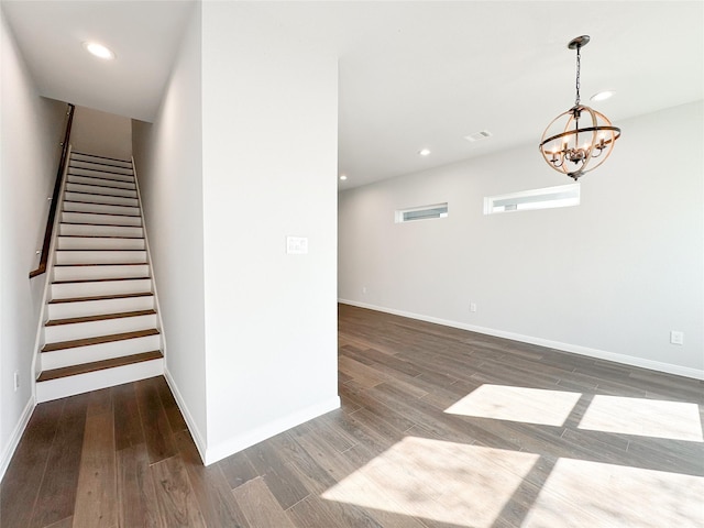 staircase with an inviting chandelier and hardwood / wood-style flooring