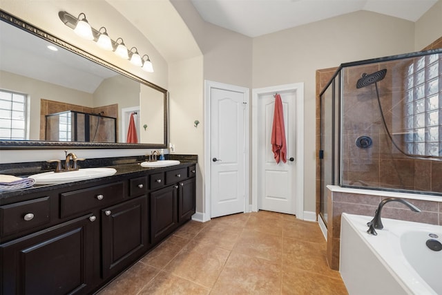 bathroom featuring tile patterned flooring, vaulted ceiling, shower with separate bathtub, and vanity