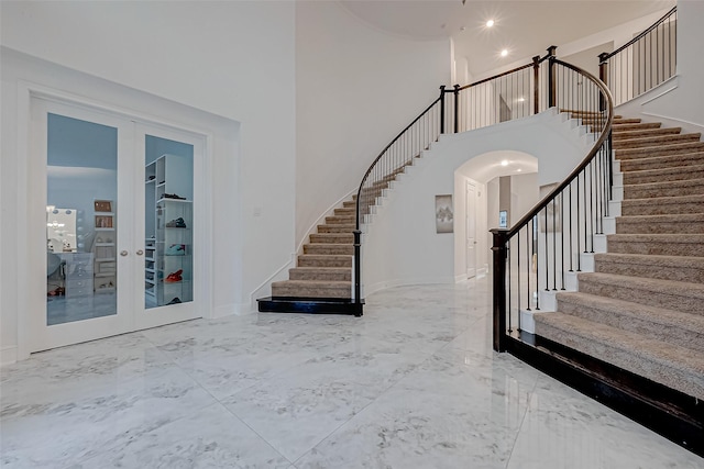 entryway featuring a high ceiling and french doors