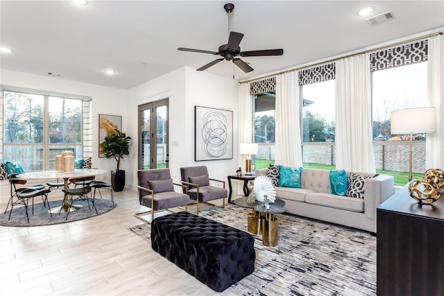 living room with light hardwood / wood-style floors, french doors, and ceiling fan