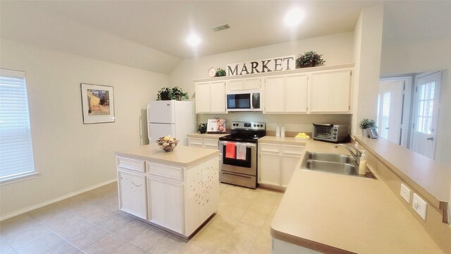 kitchen featuring electric stove, sink, white cabinetry, white refrigerator, and a kitchen island