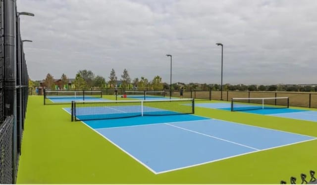 view of tennis court with basketball hoop