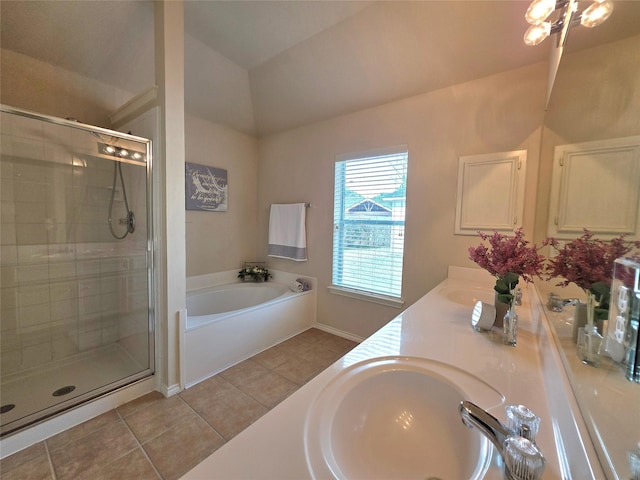 bathroom featuring tile patterned flooring, vaulted ceiling, shower with separate bathtub, and vanity