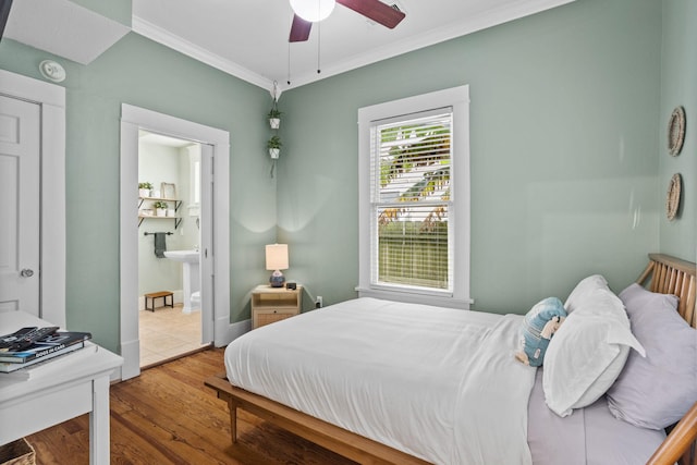 bedroom featuring crown molding, ceiling fan, ensuite bathroom, and hardwood / wood-style floors