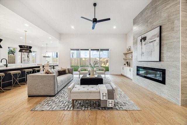 living area featuring a ceiling fan, recessed lighting, wood finished floors, and a tile fireplace