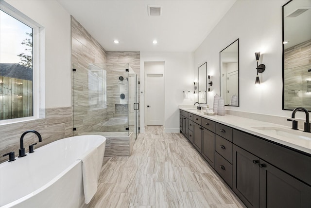 full bathroom with a sink, a freestanding tub, double vanity, and a shower stall