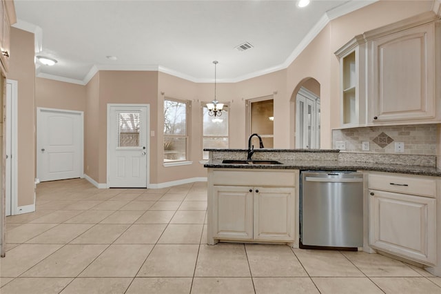 kitchen with dark stone countertops, sink, stainless steel dishwasher, and decorative light fixtures