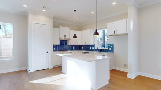 kitchen featuring hanging light fixtures, a kitchen island, and white cabinets