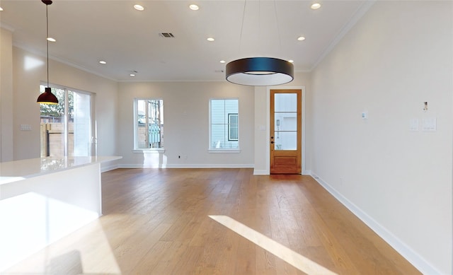 unfurnished living room with ornamental molding and light hardwood / wood-style flooring