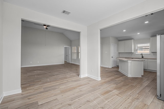 unfurnished living room with sink and light wood-type flooring