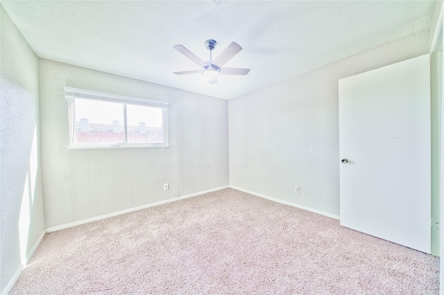 carpeted spare room with ceiling fan and a textured ceiling