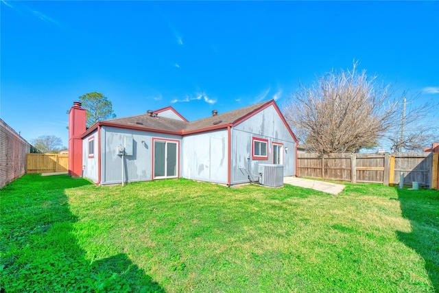 back of property featuring cooling unit and a lawn