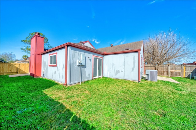 back of house with a yard and central AC unit