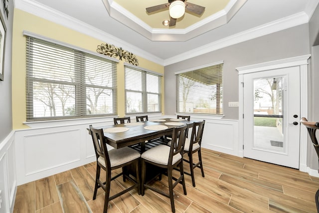 dining room with a raised ceiling, ornamental molding, and ceiling fan