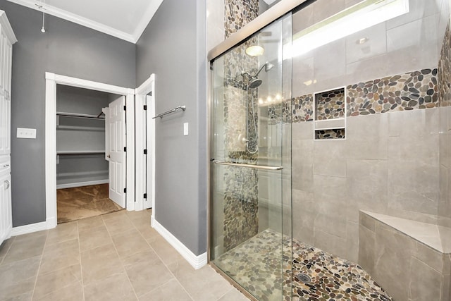 bathroom featuring ornamental molding and a shower with shower door