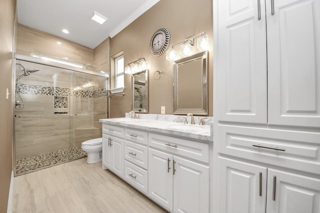 bathroom featuring vanity, hardwood / wood-style floors, a shower with door, and toilet