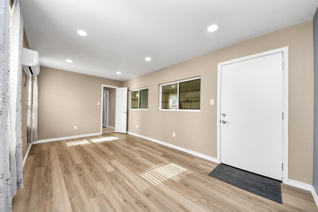 entryway featuring a wall mounted air conditioner and light hardwood / wood-style flooring