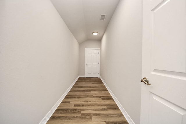 hall featuring hardwood / wood-style flooring and vaulted ceiling