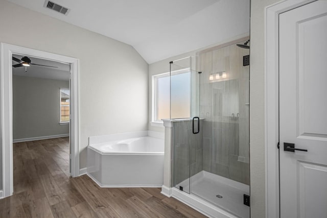 bathroom with hardwood / wood-style flooring, plenty of natural light, plus walk in shower, and vaulted ceiling