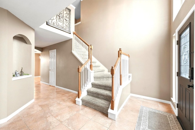 foyer entrance with a towering ceiling