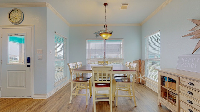 dining space featuring light wood-style floors, visible vents, crown molding, and baseboards