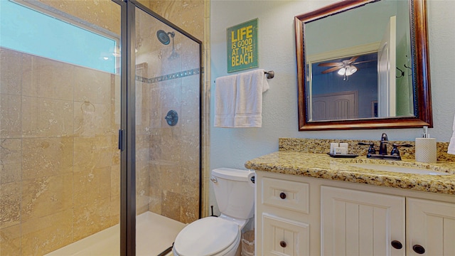 bathroom featuring a textured wall, a stall shower, vanity, and toilet