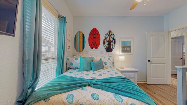 bedroom with light wood-style floors and a ceiling fan