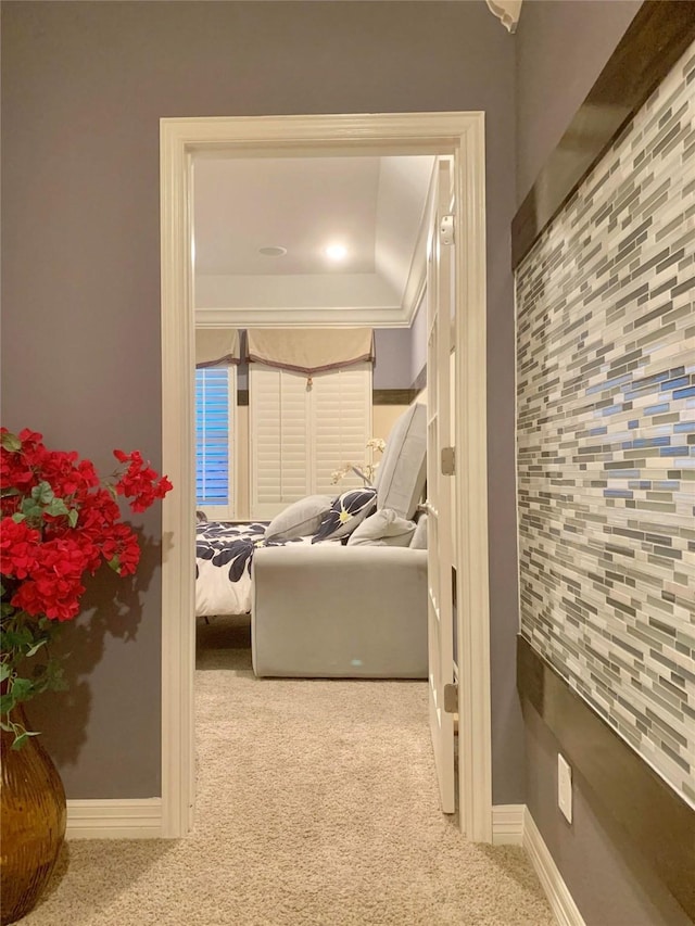 hallway with carpet flooring and baseboards