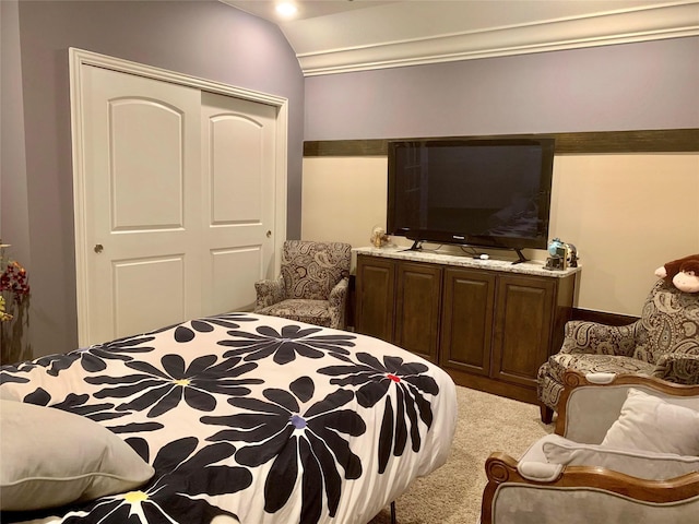 bedroom featuring lofted ceiling, a closet, and carpet flooring