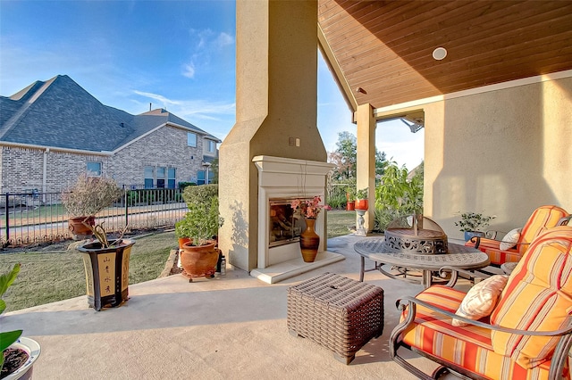 view of patio / terrace featuring a fireplace and fence