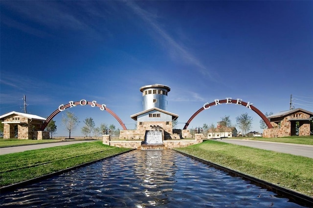 view of community featuring a water view and a lawn